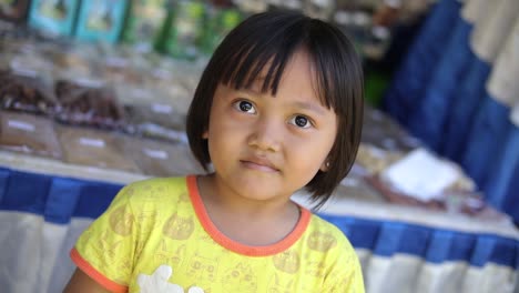 Toma-Giratoria-De-Una-Adorable-Niña-Indonesia-Sonriendo-A-La-Cámara-En-Bali,-Indonesia