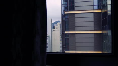 Las-Cortinas-Se-Abren-Lentamente-Y-Revelan-La-Hermosa-Vista-Del-Centro-De-Hong-Kong-Alfombrada-De-Edificios-Altos.