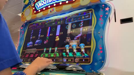 HD-video-of-an-Asian-boy-playing-"Shooting-Mania"-a-multi-player-ticket-redemption-video-game-with-a-carnival-style-theme