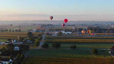 Un-Dron-Desciende-Sobre-Un-Campo-De-Maíz-Mientras-Se-Inflan-Globos-Aerostáticos-En-El-Festival-Y-Se-Elevan-A-Través-Del-Cielo-De-La-Mañana.