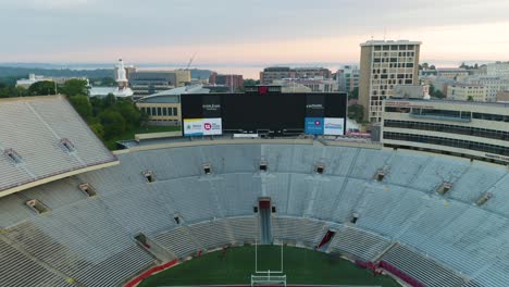 Aerial,-fly-over-of-empty-Wisconsin-gridiron-stadium-in-Madison-city,-soft-light