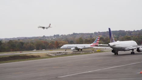 Los-Aviones-Se-Alinean-Para-El-Despegue-Mientras-Un-Avión-Llega-Para-Aterrizar-En-El-Aeropuerto-Internacional-John-Glenn-En-Columbus,-Ohio