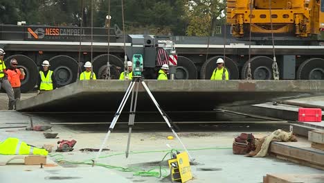 LARGE-CONCRETE-PANEL-BEING-LIFTED-INTO-PLACE-WITH-CONSTRUCTION-WORKERS