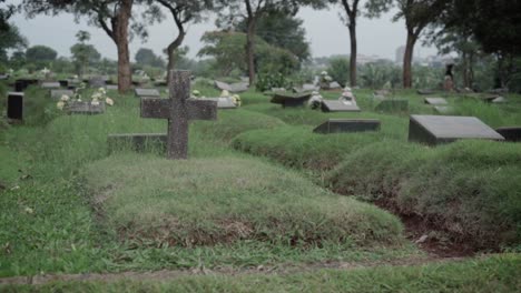 Graves-at-lawn-cemetery-with-granite-memorial-plaques-and-stone-cross