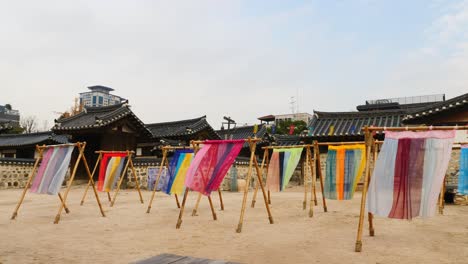 colorful-hanbok-fabric-hanging-on-traditional-korean-hanoaks-in-namsangol-hanoak-village