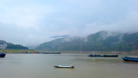 Large-and-small-cargo-and-passenger-ships-docked-on-the-Yangtze-river-shore-in-Badong,-the-starting-point-for-small-boat-trip-cruises-along-the-Shennong-stream,-Hubei-Province,-China