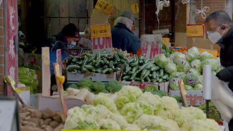 Menschen,-Die-Gesichtsmasken-Tragen,-Während-Sie-Auf-Einem-Markt-Im-Freien-Einkaufen