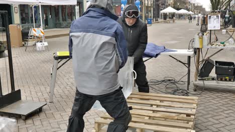 Ice-sculptors-lifting-block-of-ice.-Slomo