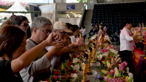 Menschen-Gießen-Wasser-Auf-Die-Baby-Buddha-Statue-Während-Der-Tempelzeremonie-Des-Buddha-Geburtstagsfestes.-Baden-Der-Buddha-Statue-Während-Der-Tempelzeremonie-Im-Neuen-Jahr