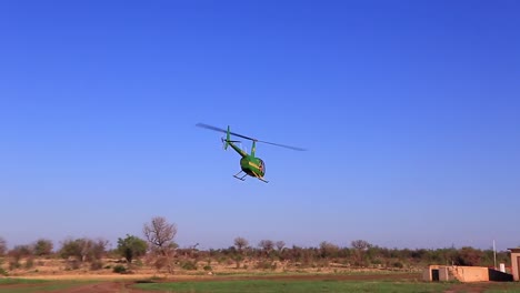 John-Deere-branded,-Robinson-Raven-II-helicopter-takes-off-in-Africa