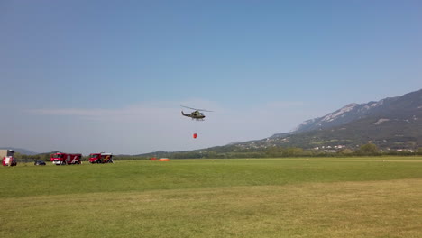 Military-helicopter-fighting-fire-with-a-water-bucket