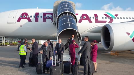 La-Tripulación-De-Cabina-Con-Uniforme-Y-Equipaje-Baja-Las-Escaleras.