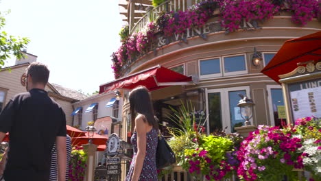 People-walking-along-a-pretty-street-on-a-sunny,-summer-day