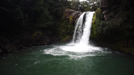 Weitwinkelaufnahme-Eines-Wasserfalls,-Der-über-Einer-Klippe-In-Neuseeland-In-Tiefes-Türkisfarbenes-Wasser-Fällt