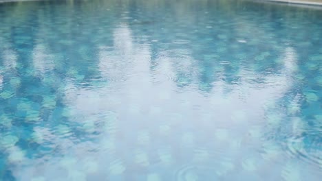 Raindrops-falling-on-the-surface-of-a-swimming-pool-slow-motion
