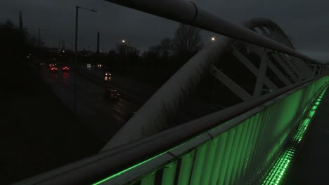 Slow-dolly-right-across-Steve-Prescott-colourful-illuminated-bridge-crossing-in-town-urban-scene-at-night