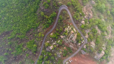 A-drone-zooms-out-revealing-a-curved-road-on-a-hilltop