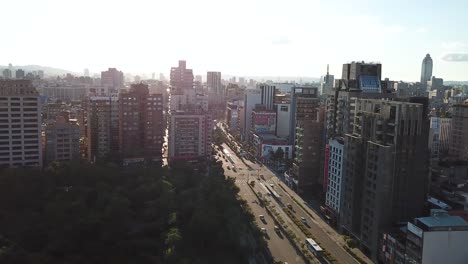 Taipei-City-Taiwan,-Xinyi-Commercial-Business-District-and-Road-Traffic,-Drone-Aerial-Overlook-on-Sunset-Sunlight