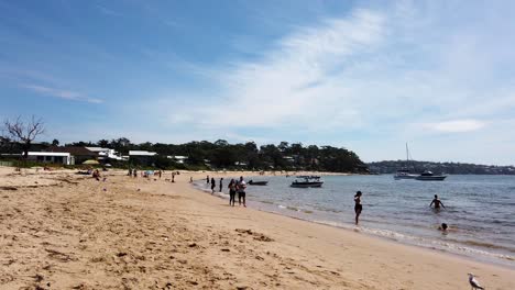 People-relaxing-or-walking-along-the-main-beach-of-Bundeena-near-Sydney-Australia
