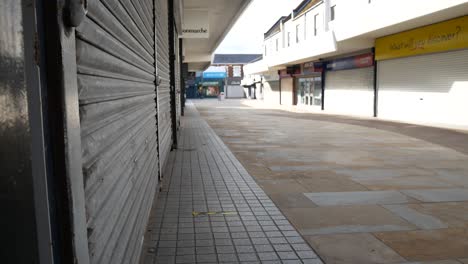 Empty-closed-corona-virus-small-town-retail-shop-security-shutter-in-empty-urban-street