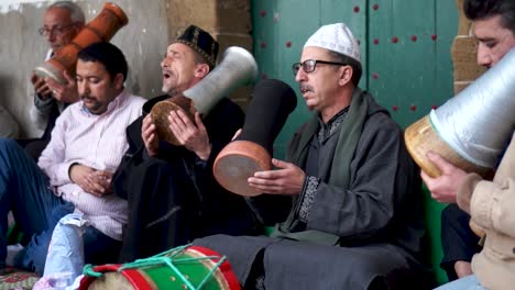 Versammlung-Von-Männern-In-Traditioneller-Kleidung,-Die-Während-Einer-Sufi-Zeremonie-Singen-Und-Trommeln-Schlagen-Und-In-Trance-Verfallen