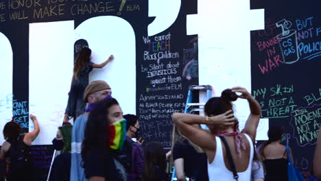 Menschenmenge-Schreibt-Nachrichten-An-Die-Wand-Bei-Chalk-The-Block-Protest