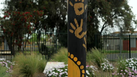 Aboriginal-Decorative-Artwork-On-Outdoor-Poles-In-A-Garden