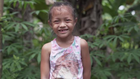 Cute-Filipina-Child-Smiling-At-The-Camera-In-A-Rural-Village-In-The-Philippines---Happiness---medium-shot