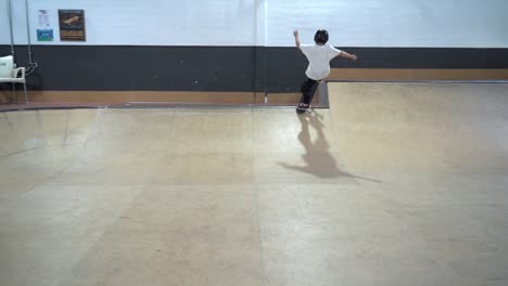 Young-skateboarder-jumping-on-ramp-and-falling-down-on-knees