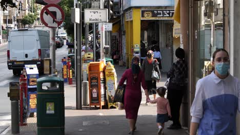 Everyday-life-in-the-city-streets-during-a-pandemic,-many-people-walk-and-shop