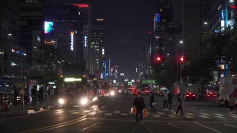 Los-Autobuses-Se-Detienen-Cuando-Los-Peatones-Cruzan-La-Calle-En-El-Distrito-De-Gangnam,-Corea-Del-Sur-Por-La-Noche---Toma-Amplia