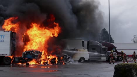 Firefighters-actively-spray-water-on-raging-rife-that-has-engulfed-semi-trucks-and-a-van-in-northern-oregon