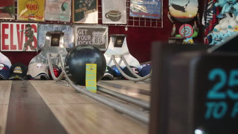 Woman's-hands-pushing-bowling-ball-at-Bowler-Roller-carnival-game,-Slow-Motion