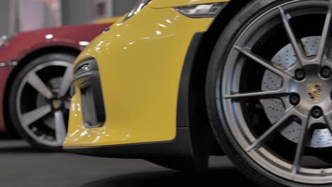 Detalle-De-Primer-Plano-De-La-Moderna-Llanta-Y-Frenos-De-Un-Coche-Deportivo-Porsche-Amarillo,-Tiro-Con-Plataforma-Rodante