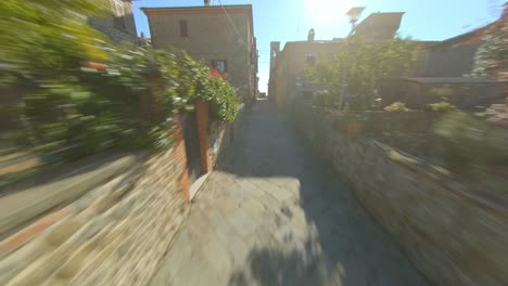 Aerial-view,-fast-dolly-forward-between-old-alleys-of-an-Italian-village