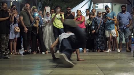 Grupo-De-Breakdance-Bailando-En-Una-Calle-Concurrida-Por-La-Noche