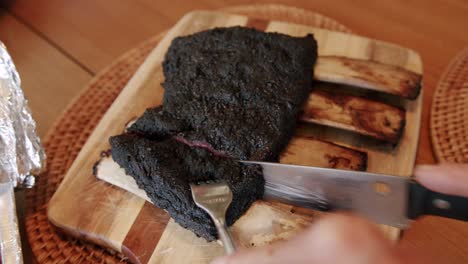 Das-Messer-Schnitzt-Auf-Einem-Schneidebrett-Langsam-In-Gegrillte-Kurze-Rinderrippen