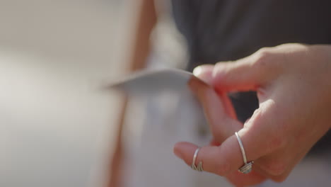 Young-Female-Hand-Fans-Polaroid-Film-to-Expose,-Slow-Motion,-Close-Up