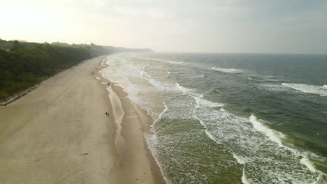 Aerial-Pull-Back-over-Baltic-Sea-Beach-in-Poland-with-Green-Waves