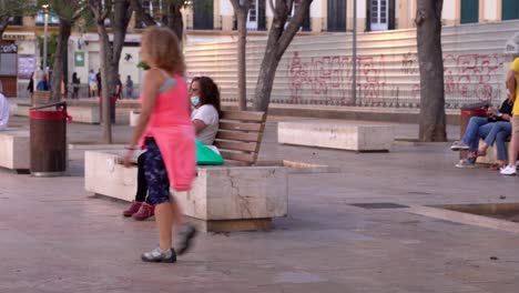 People-enjoying-Plaza-de-Merced,-wearing-face-mask-in-pandemic