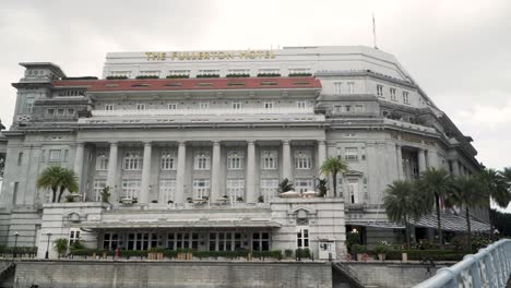 Das-Fullerton-Hotelgebäude-Von-Der-Cavenagh-Bridge-über-Den-Singapore-River-Aus-Gesehen-–-Schwenk-Nach-Links