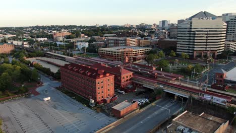 Aerial-pullback-reveals-Wilmington-Delaware-Amtrak-train-station,-Chase-Bank,-city-skyline,-home-of-Vice-President-VP-Joe-Biden,-Christina-River