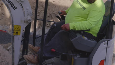 Operador-De-Equipo-Con-Sobrepeso-Que-Trabaja-En-Una-Miniexcavadora,-También-Conocida-Como-Azada-De-Oruga,-Reducida-A-La-Mitad-De-La-Velocidad