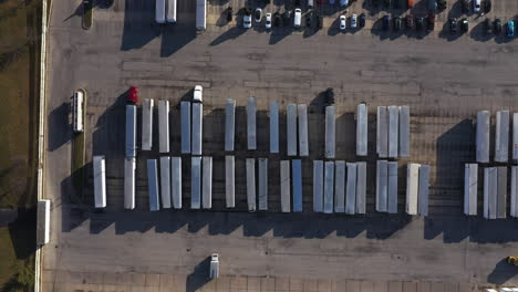 Top-down-rising-aerial-shot-high-above-a-parking-lot-full-of-semi-trailers-and-trucks-near-Chicago