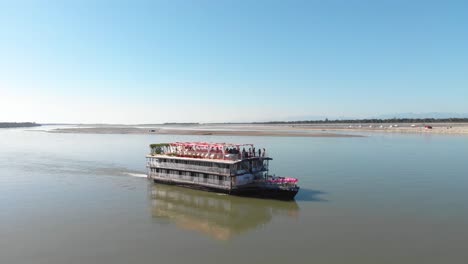 4K-drone-shot-of-yacht-sailing-on-beautiful-Brahmaputra-river-on-a-bright-sunny-day
