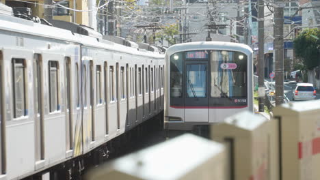 Dos-Trenes-Se-Encuentran-En-Las-Vías-Del-Tren-Cerca-De-La-Estación-En-Tokio,-Japón---Tren-Jr-Acercándose-A-La-Estación
