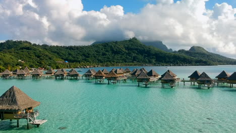 aerial-view-of-overwater-bungalows-at-the-coastline-of-Bora-Bora,-French-Polynesia---Dolly-up