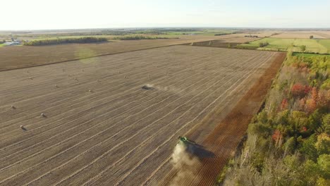 A-combine-cuts-corn-stalks-and-piles-chaff-for-the-baling-machine-following-behind-gathering-the-material-into-large-round-bales-for-winter