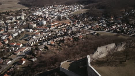 Flying-above-old-castle-on-Hill-in-Hainburg-and-revealing-urban-area,-Aerial-shot,-Austria