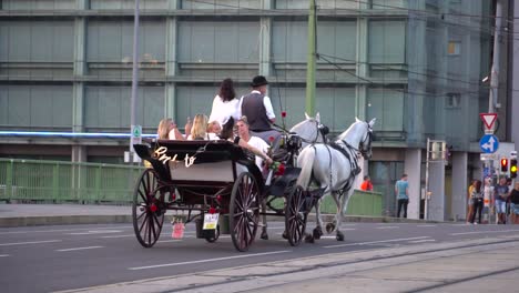 Slow-motion-view-of-horse-carriage-with-bride-and-bridesmaids-in-Vienna,-Austria